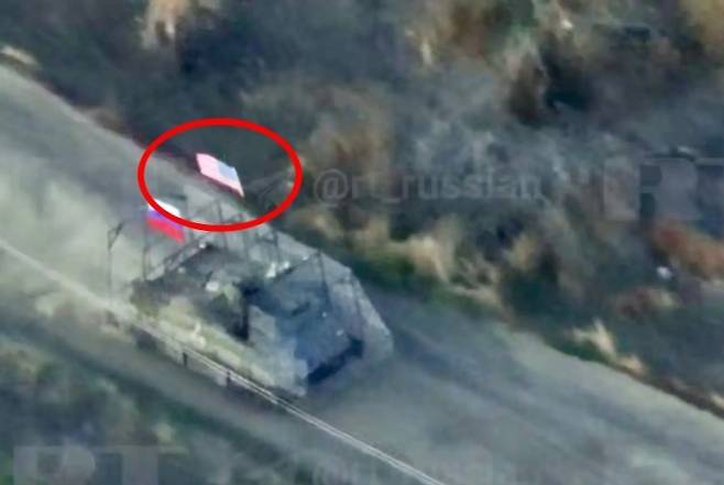 러시아 국영 매체 RT가 18일(현지시간) 공개한 영상. 러시아 국기와 미국 국기를 단 미군 장갑차가 자포리자주에서 우크라이나군 진지를 급습하는 모습. RT 영상 캡처