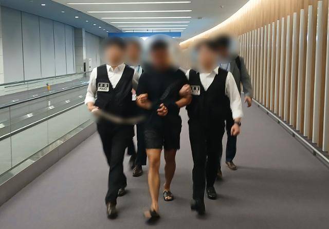 법무부는 22일 380억 원 이상을 편취한 해킹 범죄조직의 총책급 A씨(가운데)를 태국 방콕에서 인천공항으로 송환했다고 밝혔다. 법무부 제공