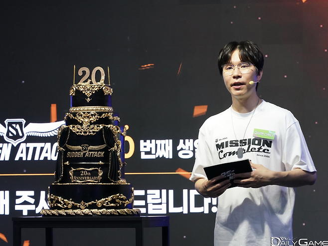 20주년 기념 케이크 옆에 선 김태현 디렉터가 이용자들에 감사의 인사를 전했다.