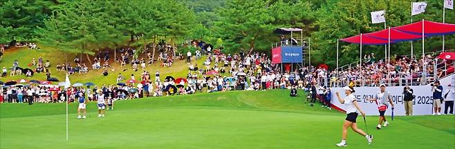 경기 포천시 포천힐스CC에서 24일 열린 한국여자프로골프(KLPGA)투어 'BC카드·한경 레이디스컵' 최종 4라운드 마지막 18번 홀(파5)에서 김민솔(오른쪽)이 11m 이글 퍼트를 떨어뜨린 뒤 오른손을 불끈 쥐며 기뻐하고 있다. 매년 손에 땀을 쥐게 하는 명승부로 유명한 '행운의 언덕'에는 이날 4000여 명의 골프 팬이 경기를 보기 위해 모였다. 포천=이승재 기자