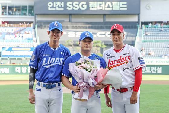 삼성 오승환(가운데)이 7일 인천 SSG랜더스필드에서 열린 은퇴 기념행사에서 구자욱(왼쪽)과 SSG 김광현으로부터 꽃다발을 선물 받은 뒤 기념촬영을 하고 있다. 2025.8.7. 뉴스1