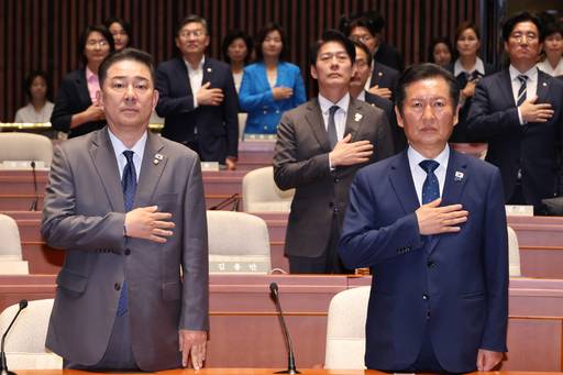 더불어민주당 정청래 대표와 김병기 원내대표(왼쪽)가 27일 서울 여의도 국회에서 열린 의원총회에서 국기에 경례하고 있다. 사진=연합뉴스