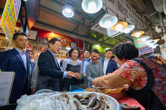 이재명 대통령과 김혜경 여사가 서울 은평구 연서시장을 방문해 순대 등을 구매하고 있다. 대통령실 제공 및 뉴시스