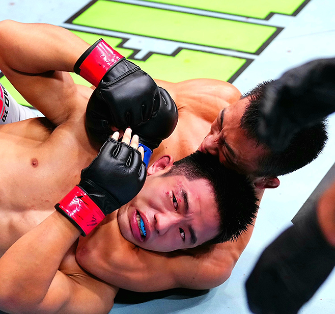 AFC 웰터급 챔피언 김상욱이 2025년 8월 상하이다우타이 Road to UFC 시즌4 라이트급 토너먼트 4강전에서 중국 우슈 산타 전우훈 전국대회 우승자 런야웨이를 조르기로 굴복시키고 있다. 사진=TKO