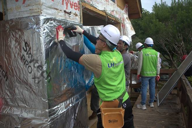 같은 날 참가자들이 노후주택의 외벽을 보수하고 있다.