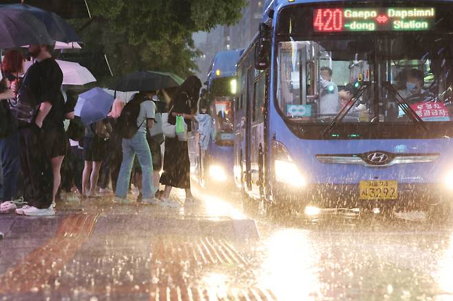 호우주의보가 내려진 지난 7월 16일 서울 강남역 인근에서 시민들이 버스를 기다리고 있다. 연합뉴스