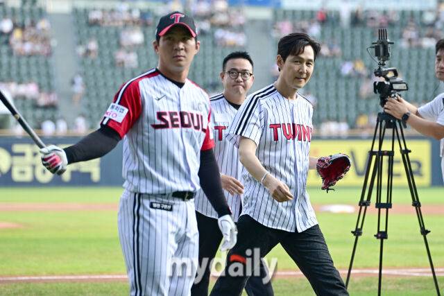 ▲ 몸을 풀고 있는 LG 오지환(왼쪽)을 피해 재 촬영을 위해 이동하는 이정재.