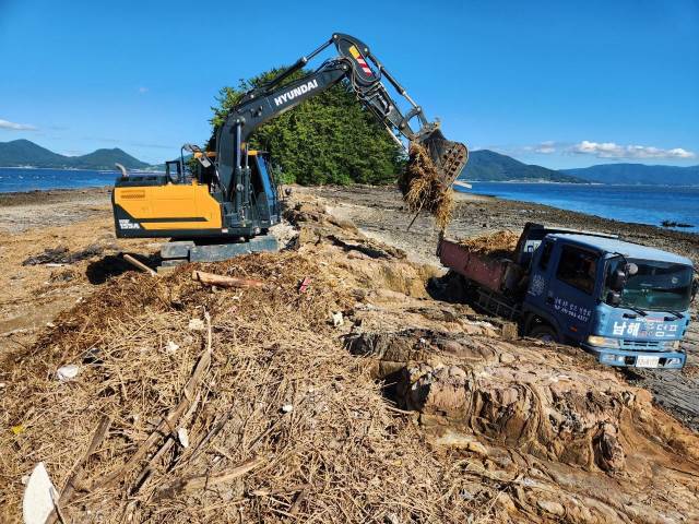 지난 7월 집중호우로 인한 해양쓰레기 수거작업을 하고 있다./경남도/