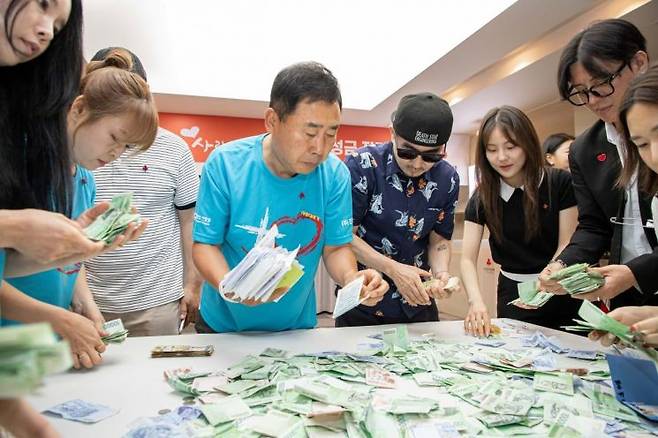 가수 박상민 씨와 개그맨 황기순 씨가 직원들과 함께 ‘사랑더하기’ 거리 모금 성금을 집계하고 있다. 사랑의열매
