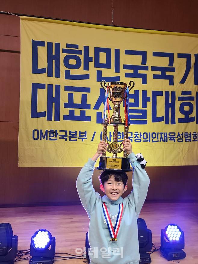 지난 3월 ‘2025 세계창의력 올림피아드 국가대표 선발대회’에서 대상 수상 후 트로피를 들어올리고 있는 차동준(용인 청덕초5)군. 동준군은 용인미르아이공유학교와 경희대가 연계한 ‘AI SW 공유학교’에서 배운 블록코딩 인공지능 알고리즘을 대회에서 활용했다. (사진=차동준군 어머니 오윤아씨 제공)