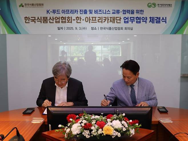 박진선 한국식품산업협회 회장과, 김영채 한·아프리카재단 이사장이 3일 업무협약 체결 문서에 서명하고 있다. 한국식품산업협회 제공