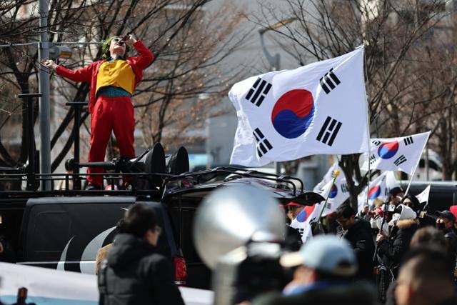 윤석열 전 대통령 탄핵 심판 정국이 펼쳐졌던 3월 3일 서울 동작구 중앙대 정문에서 탄핵 반대 집회가 열리고 있다. 배인규 신남성연대 대표가 영화 '조커' 분장을 한 채 차량 위에 올라 소리치는 모습. 배씨는 유튜브를 통해 남성 청소년, 청년들과 활발히 소통했다. 연합뉴스