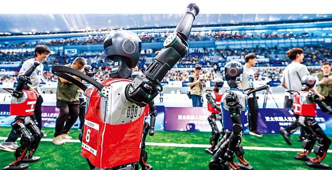 < 환호하는 칭화대 로봇 > 중국 칭화대 소속 휴머노이드 로봇이 중국 최초의 완전자율 3 대 3 로봇 축구 대회 결승전에서 승리 세리머니를 하고 있다. 신화연합뉴스