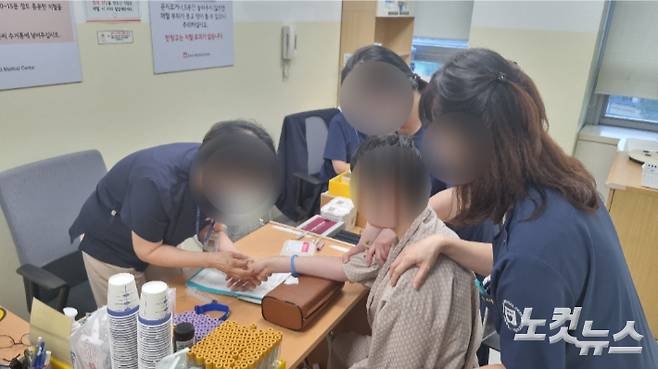 4일 서울 중랑구 서울의료원에서 한 발달장애인이 기본 검사를 마치고 채혈하고 있다. 의료진이 수차례 상황을 설명하고 안심시키는 모습. 김지은 기자