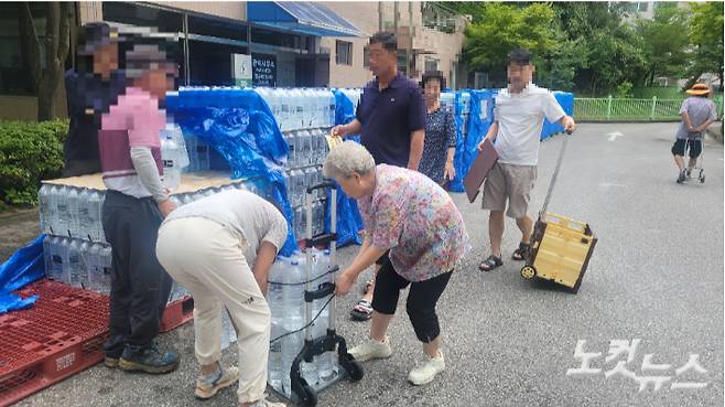 4일 오후 강릉시 교동의 한 아파트에서 주민들에게 생수를 배부하고 있는 모습. 전영래 기자