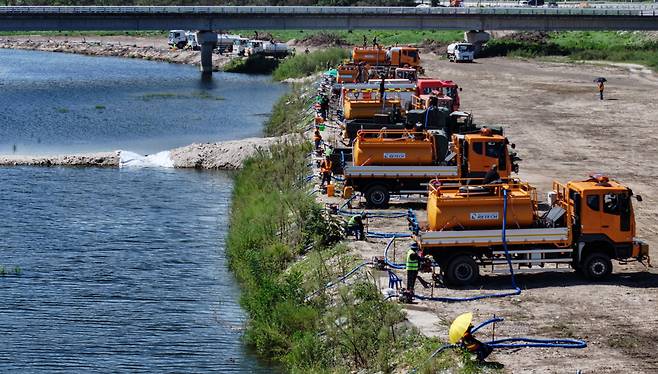 지난 5일 강원 강릉시 외곽의 한 하천에서 전국에서 모인 살수차와 소방차, 군용차가 오봉저수지에 투입할 물을 담고 있다. /장경식 기자