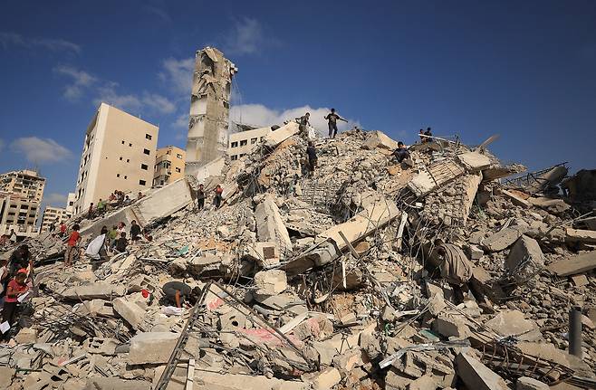 6일 이스라엘군의 공습으로 무너진 건물에서 팔레스타인인들이 현장을 둘러보고 있다. 로이터연합뉴스