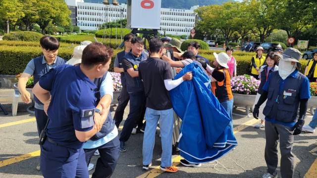 8일 민주노총 경남지역본부가 경남도청 앞에 천막을 설치하는 과정에서 청원경찰과 마찰을 빚고 있다. /어태희 기자/