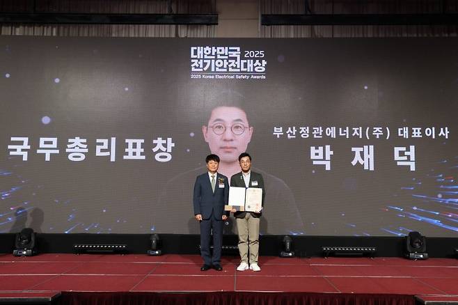 박재덕 부산정관에너지 대표(오른쪽)가 지난 8일 '제28회 대한민국 전기안전대상' 시상식에서 국무총리 표창을 수상한 뒤 기념촬영을 하고 있다. SK이노베이션 E&S 제공