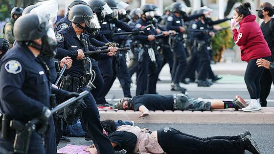 지난 6월 9일(현지시간) 미국 캘리포니아주 샌타애나에서 이민세관단속국(ICE)의 급습 소식이 전해진 뒤 진압 장비를 갖춘 경찰이 시위대와 대치하고 있다. AFP=연합뉴스