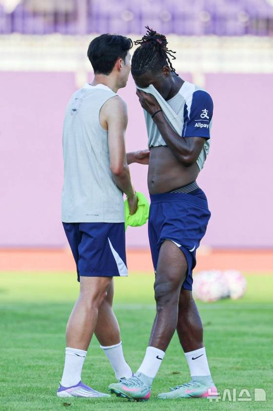 이브 비수마(오른쪽)가 지난 2일 안양시 동안구 안양종합운동장에서 열린 토트넘 오픈 트레이닝에서 손흥민(왼쪽)을 지나치며 유니폼으로 눈가를 닦고 있다. /사진=뉴시스