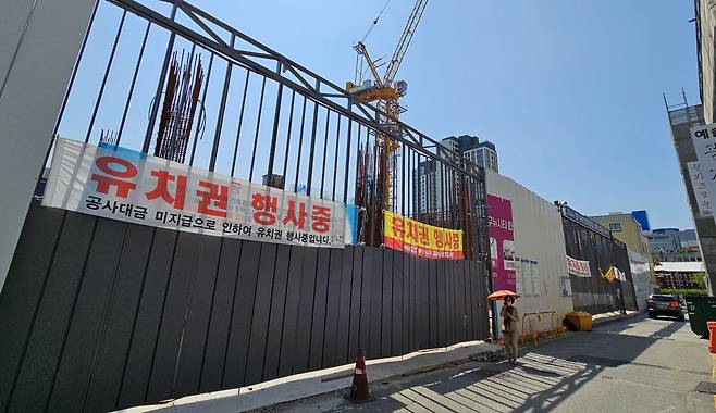 한때 유치권 현수막이 내걸렸던 서울 아파트 공사 현장. 현재 법원 경매 물건 10건 중 4건이 부실채권인데 앞으로 물량이 더 나올 가능성이 높아 AI를 활용한 온라인 NPL 플랫폼 '엔플랫폼'이 거래 병목을 풀 대안으로 주목받고 있다. /연합뉴스