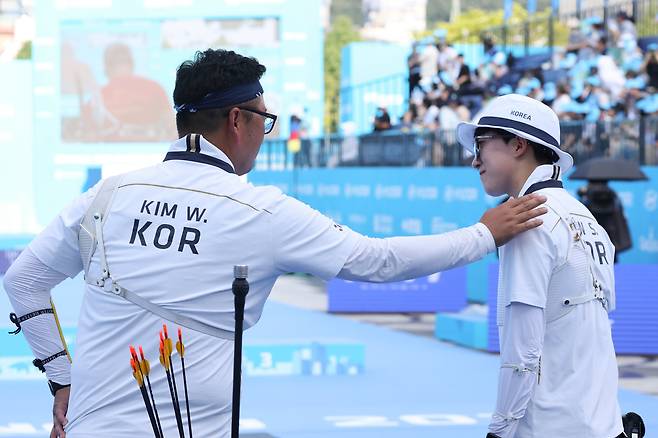 한국 양궁 대표팀 김우진(왼쪽)이 10일 광주광역시 5·18 민주광장에서 열린 2025 세계양궁선수권대회 혼성 단체전 결승에서 안산을 격려하고 있다./연합뉴스