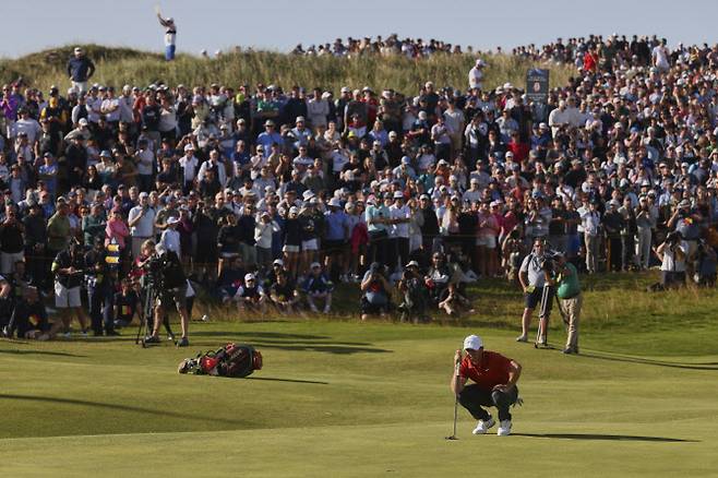 20일(한국시간) 영국 북아일랜드 포트러시의 로열 포트러시 골프장에서 열린 제153회 디오픈 챔피언십 3라운드. 로리 매킬로이가 퍼트 라인을 살피고 있고, 뒤에 수많은 팬들이 이를 지켜보고 있다.(사진=AP/뉴시스)