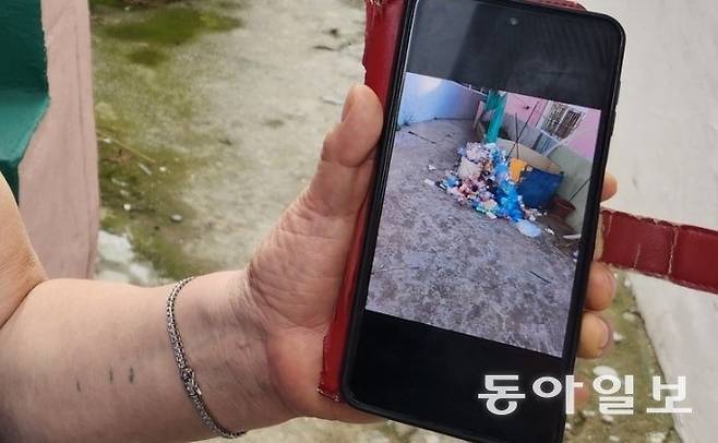 감천문화마을 주민이 관광객들이 버리고 간 쓰레기 사진을 보여주며 생활 불편을 호소하고 있다. 김화영 기자 run@donga.com