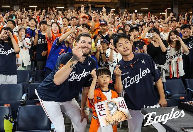 코디 폰세(한화 이글스)가 13일 대전 한화생명 볼파크에서 열린 2025 KBO리그 키움 히어로즈와 경기에서 선발 17연승을 이어간 뒤 응원단상에서 팬과 함께 기념 사진을 찍고 있다. 한화 이글스 제공