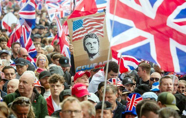 영국 런던에서 13일(현지시간) 열린 반이민 집회에서 한 참가자가 최근 암살된 미국 우익 활동가 찰리 커크의 얼굴과 성조기가 그려진 팻말을 들고 있다. EPA연합뉴스