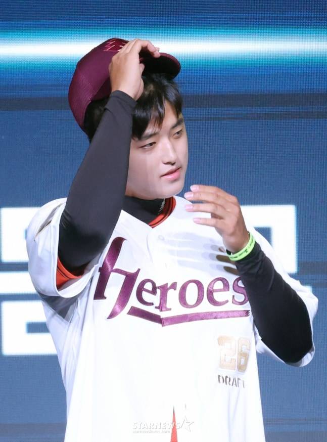 '2026 KBO 신인 드래프트'가 17일 서울 송파구 롯데호텔 월드 크리스탈볼룸에서 열렸다. 박준현이 전체 1순위로 키움에 지명된 후 키움 허승필 단장의 도움을 받아 유니폼을 입고 있다. /사진=김진경 대기자