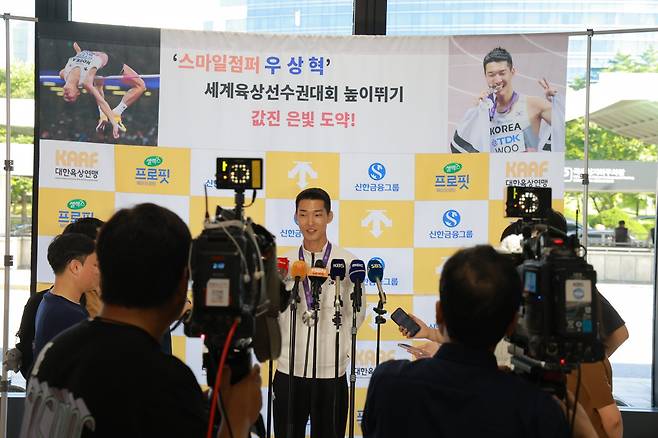 ‘스마일 점퍼’ 우상혁(가운데)이 18일 김포공항에서 열린 귀국 기자회견에서 2025세계육상선수권 남자 높이뛰기에서 은메달을 수확한 소감을 설명하고 있다. 그는 지난달 10일 유럽전지훈련 도중 종아리와 발목을 다쳤지만 이를 딛고 한국육상 역대 최고 성적과 타이인 은메달을 따냈다. 사진제공│대한육상연맹