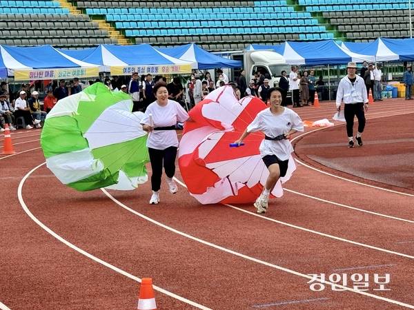 20일 여주종합운동장 트랙에서 열린 읍면동 체육대회 400m 계주에서 참가자들이 낙하산을 매고 달리기 경기를 펼치고 있다. 2025.9.20 여주/양동민기자 coa007@kyeongin.com