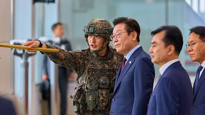 이재명 대통령이 12일 강원도 화천 7사단에서 군 관계자의 설명을 듣고 있다.