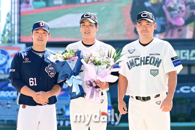 경기 전 진행된 2,000탈삼진 시상식에서 김광현이 두산 최원준(왼쪽)과 SSG 노경은(오른쪽)에게 꽃다발을 받은 뒤 포즈를 취하고 있다.
