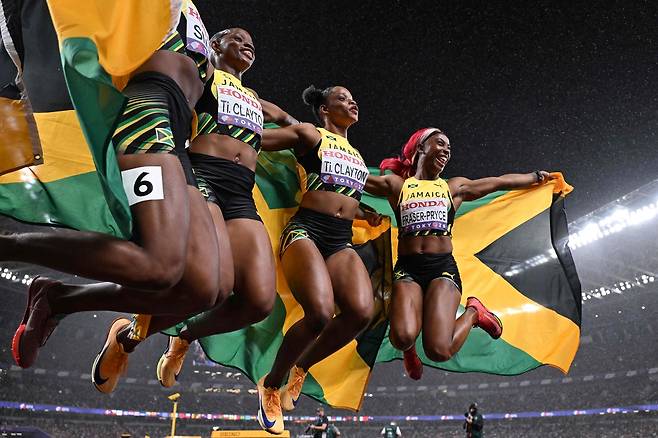(왼쪽부터) 자메이카의 조니엘 스미스, 티아 클레이턴, 티나 클레이턴, 셸리앤 프레이저-프라이스가 지난 21일 일본 도쿄에서 열린 세계육상선수권 여자 4x100m 계주 결승에서 2위를 차지한 뒤 함께 기뻐하고 있다. AFP