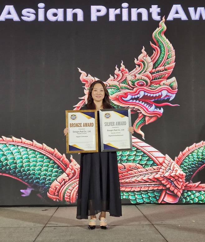 최은서 동인피오디 대표가 지난 19일 태국 방콕에서 열린 '아시안 프린트 어워드(Asian Print Awards) 2025'에서 디지털 장식 부문(Digital Embellishment) 은상과 디지털 캘린더 부문(Digital Calendars) 동상을 수상한 뒤 기념촬영하고 있다. 동인피오디는 이번 시상식에 앞서 대전의 마스코트인 꿈씨패밀리(꿈돌이)를 활용한 2026년 캘린더를 2개 부문에 출품했다. /동인피오디 제공