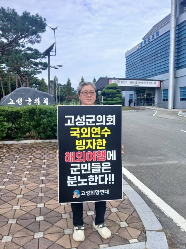 고성희망연대 소속 한 회원이 오는 20일부터 5박 6일간 일정으로 예정된 고성군의회 국외 출장을 '외유성 국외여행'이라고 비판하며 군의회 앞에서 1인 시위를 하고 있다. /고성희망연대
