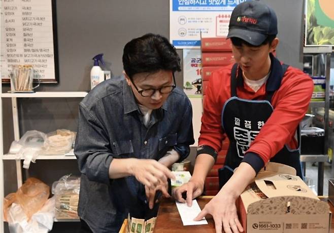 한동훈 전 국민의힘 대표가 23일 경남 진주 소재 치킨 프랜차이즈 점주와 영수증을 함께 보며 대화를 나누고 있다. 한동훈 전 국민의힘 대표 인스타그램 캡처