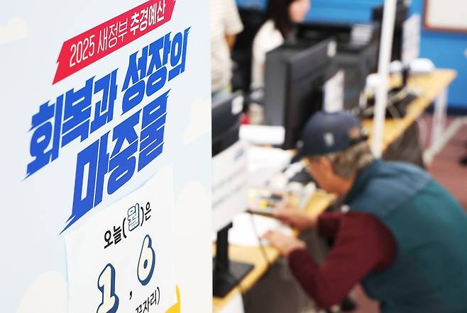 '2차 민생회복 소비쿠폰' 신청 첫날인 22일 경기도 수원시 팔달구 인계동 행정복지센터에서 시민이 소비쿠폰을 신청하고 있다. 연합뉴스