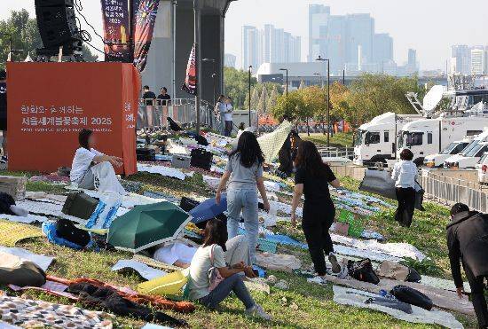 '서울세계불꽃축제 2025'를 하루 앞둔 26일 행사장 주변에서 시민들이 돗자리를 펴고 자리를 선점하고 있다.<저작권자(c) 연합뉴스, 무단 전재-재배포, AI 학습 및 활용 금지>