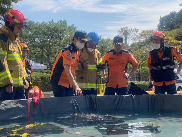 김승룡 소방청장 직무대행이 27일 국가정보자원관리원 화재 현장에서 소화수조에 담긴 불에 탄 리튬이온 배터리를 살펴보고 있다. 소방청 제공