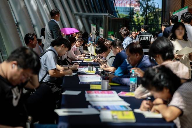 지난 11일 서울 영등포구 FKI타워에서 열린 희망 업 취업박람회를 찾은 구직자들이 이력서를 작성하고 있다. 뉴시스 제공