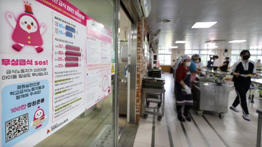 조리원들의 무기한 파업이 시작된 30일 대전 서구 둔산여자고등학교 급식실에 학교비정규직노조의 '무상급식 SOS' 안내문이 붙어 있다. 안쪽에서는 교직원과 남은 조리원이 급식을 배식하고 있다. 김영태 기자