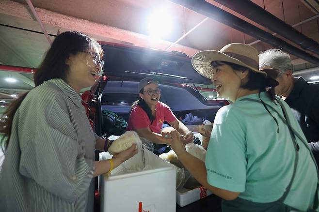 서울 서초구 서울행정법원 주차장에서 주휘씨(가운데)와 동료들이 음식을 준비하며 대화를 나누다 웃고 있다.