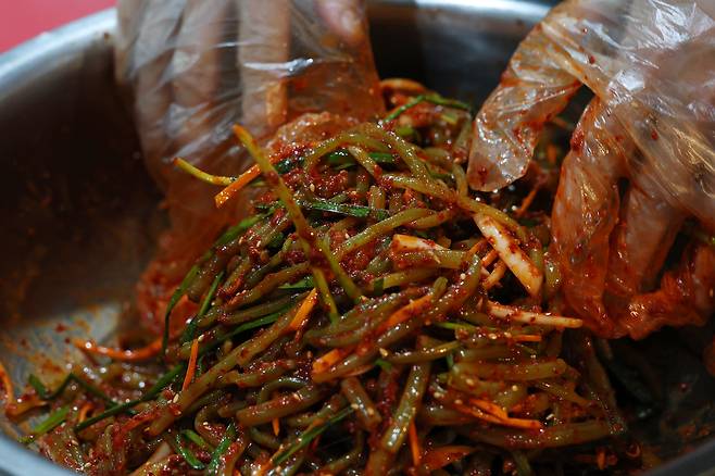 주휘씨가 ‘짜긍곰의 부엌’에서 고구마 줄기 김치를 무치고 있다.