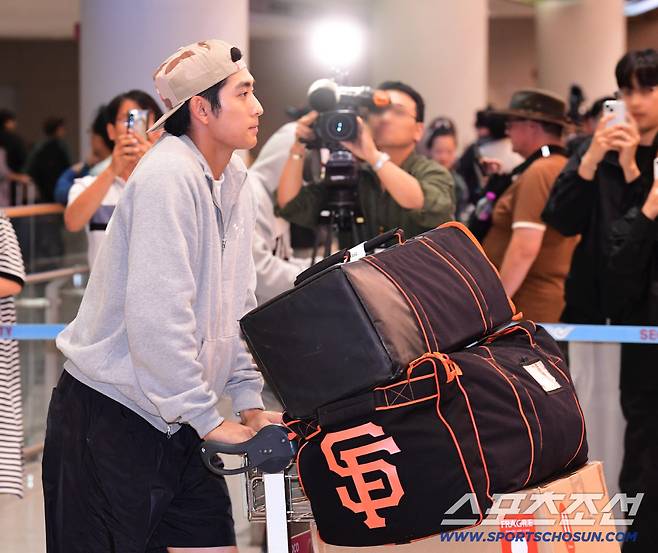 팬들과 취재진이 지켜보는 가운데 입국장 나서는 이정후.