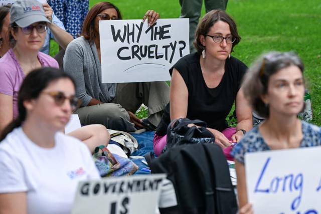 해고된 미국 연방정부 노동자들이 지난달 30일 미 워싱턴 연방의회 의사당 밖에 앉아 항의 시위를 하고 있다. 한 집회 참가자가 든 손 팻말에 “왜 이렇게 잔인한가”라는 문구가 적혀 있다. 워싱턴=로이터 연합뉴스