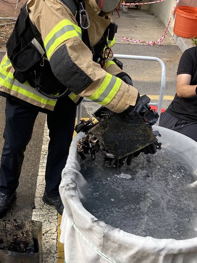 소방관이 화재로 연소된 리튬이온 배터리를 들어보이고 있다. 손인규 기자